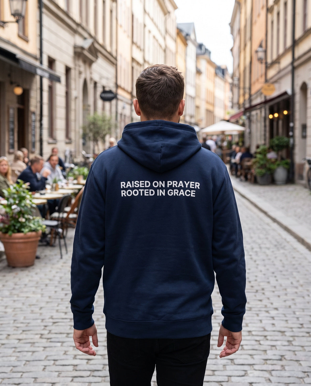 Back of a navy Raised on Prayer. Rooted in Grace Christian hoodie showing the large back print