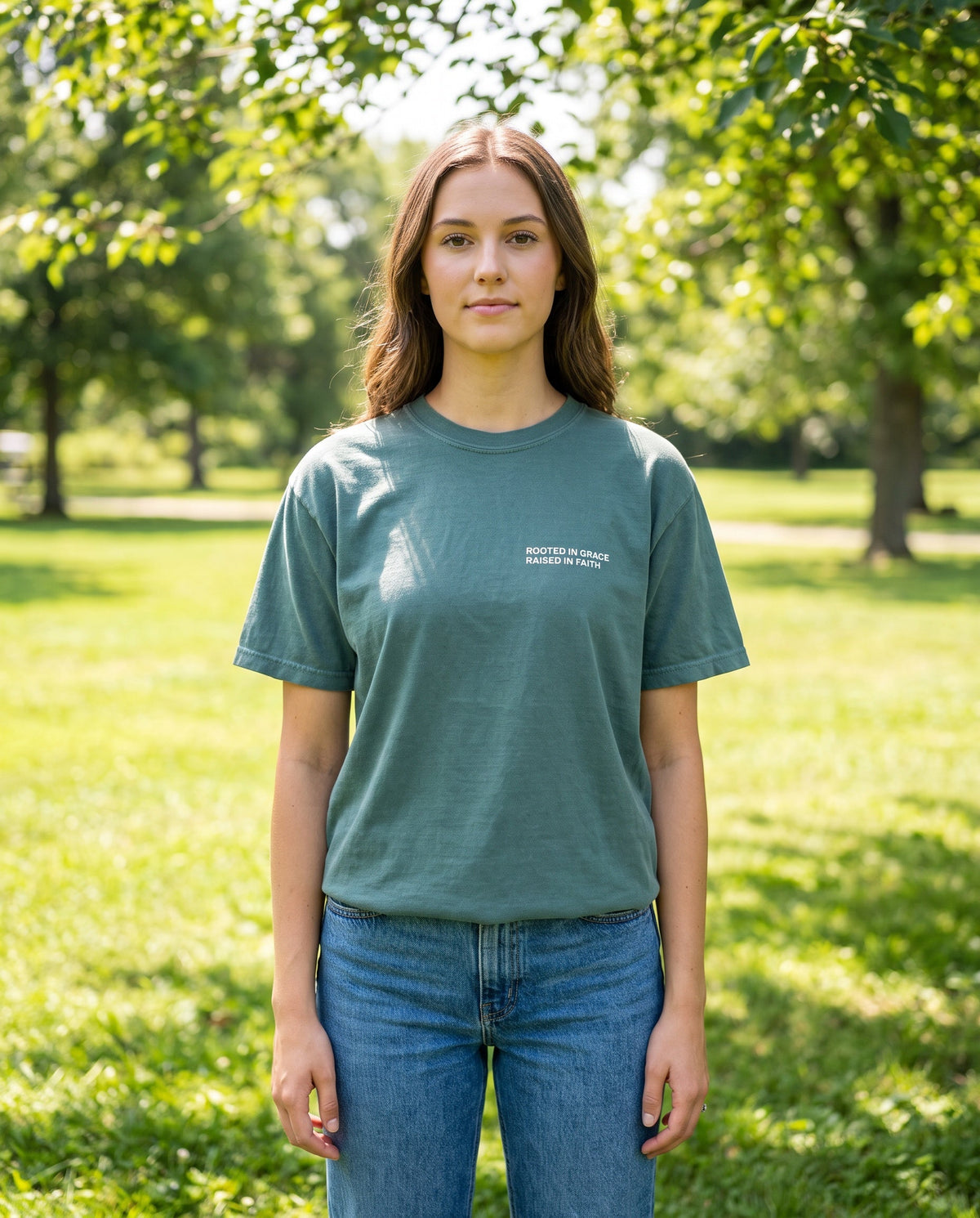 Woman wearing a bluespruce Rooted in Grace. Raised in Faith Christian t-shirt, chest print