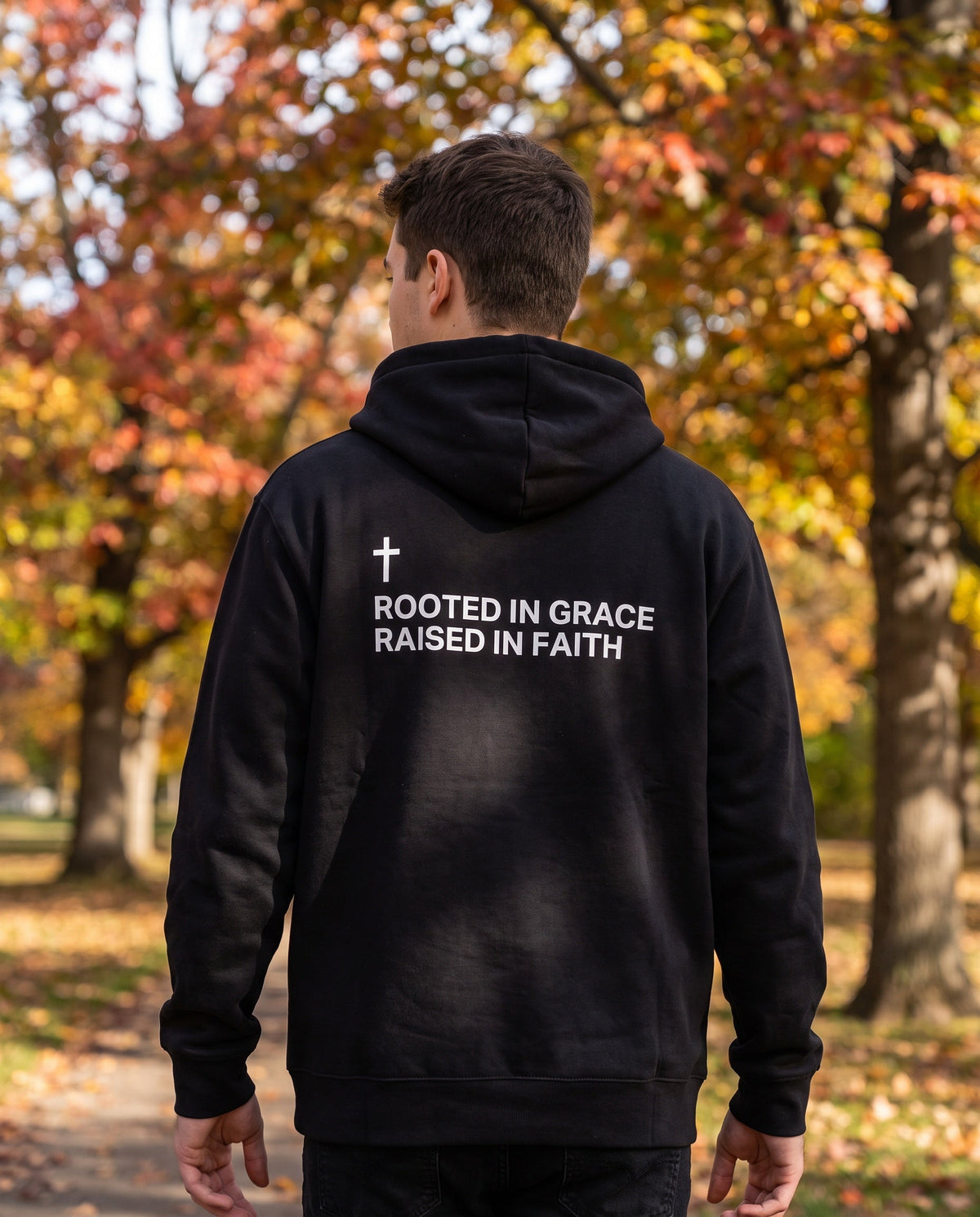 Back of a black Rooted in Grace. Raised in Faith Cross Edition Christian hoodie showing the large back print