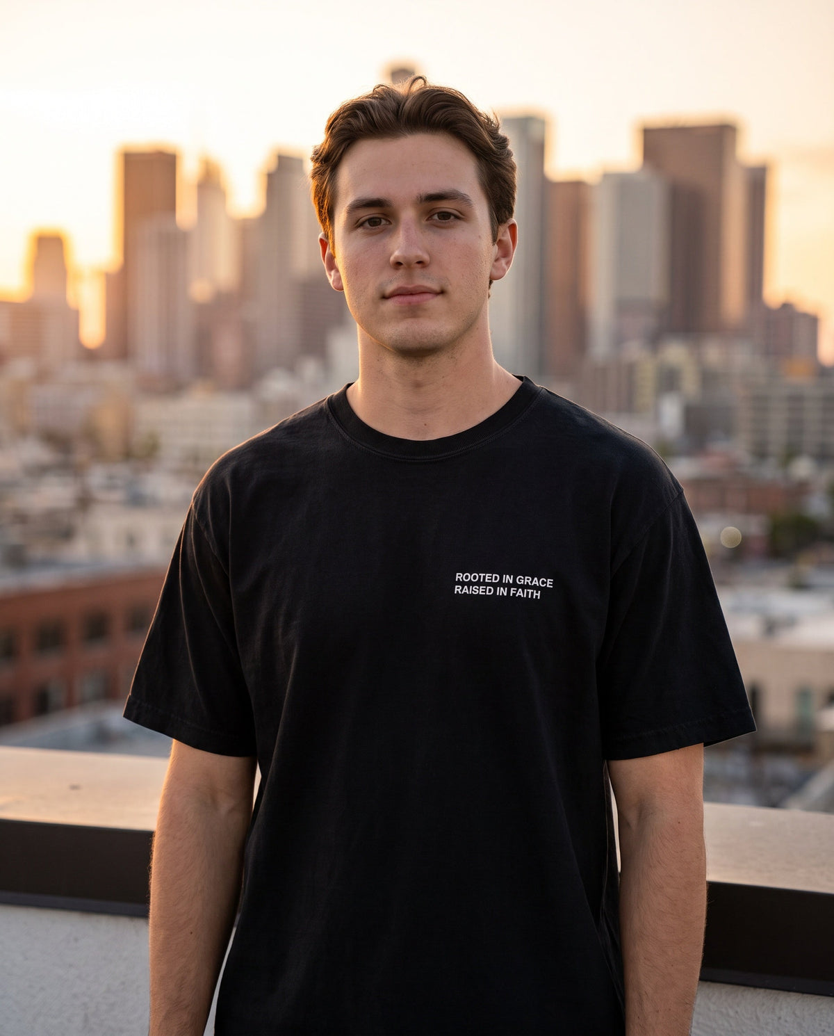 Man wearing a black Rooted in Grace. Raised in Faith Christian t-shirt, chest print