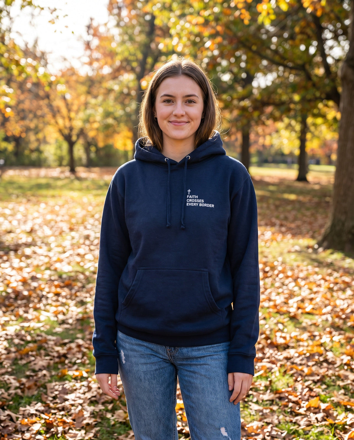 Woman wearing a navy Faith Crosses Every Border Cross Edition Christian hoodie with cross chest print