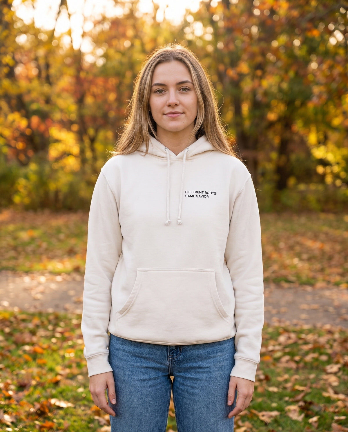 Woman wearing a bone Different Roots. Same Savior Christian hoodie, chest print