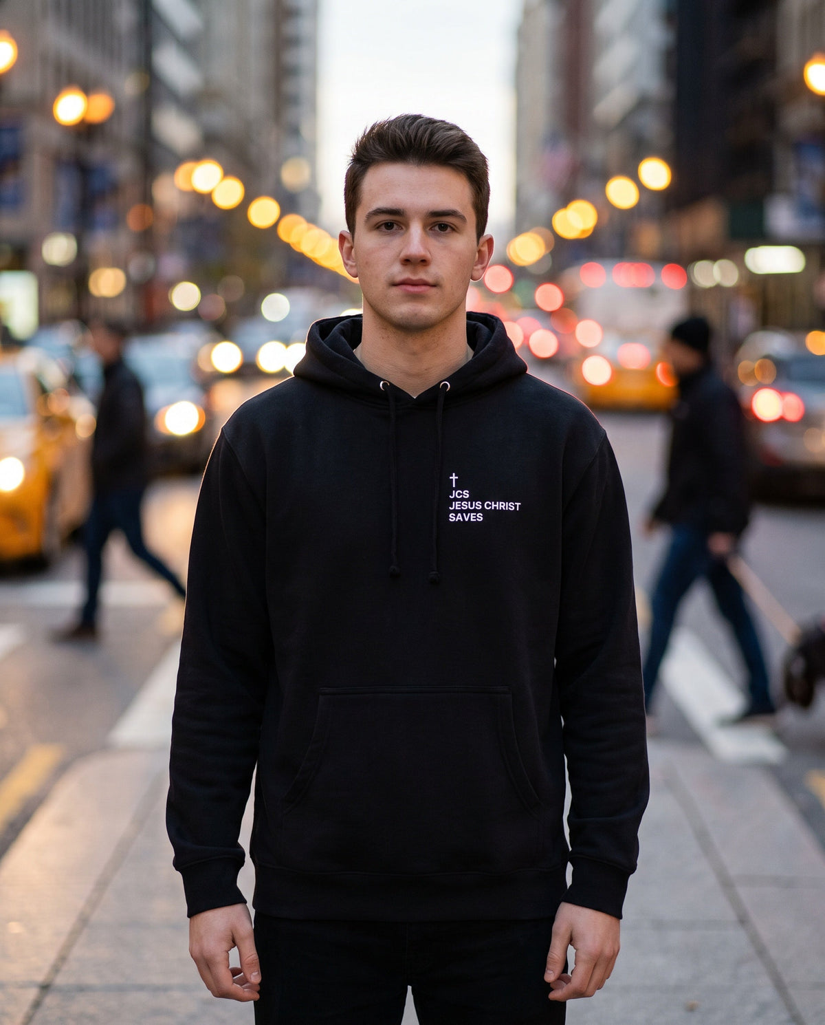 Man wearing a black JCS — Jesus Christ Saves Cross Edition Christian hoodie with cross chest print