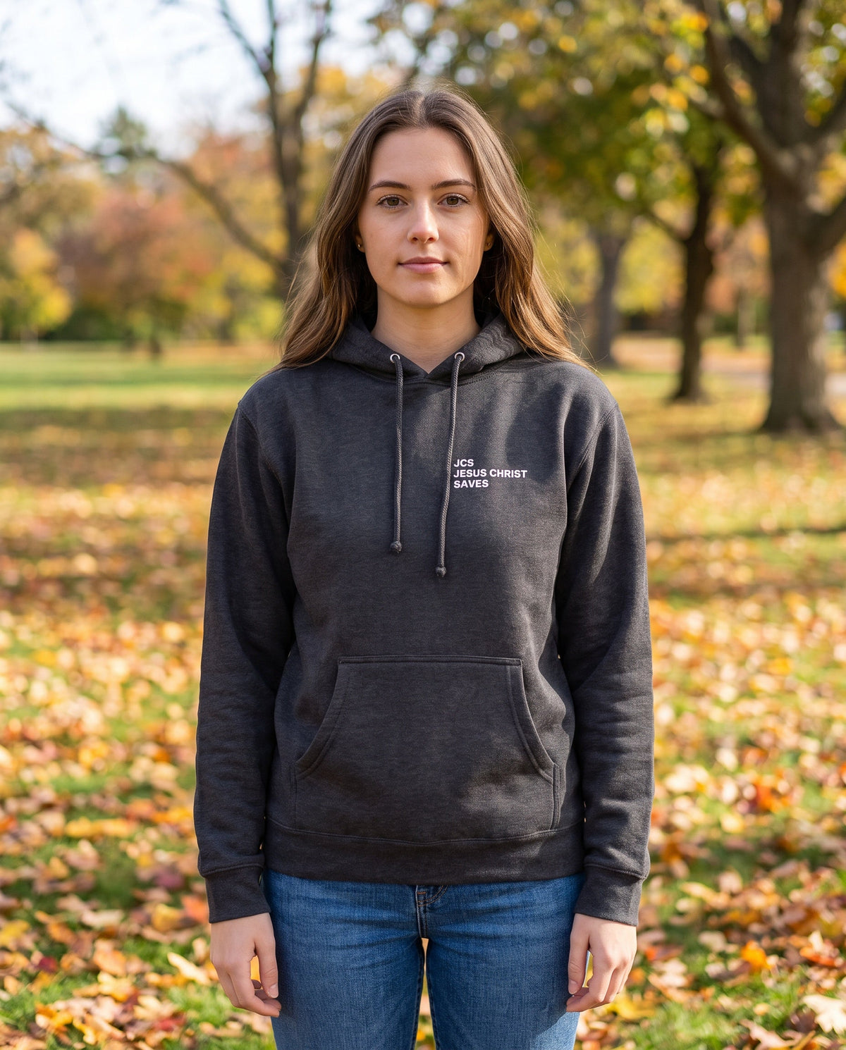 Woman wearing a charcoal JCS — Jesus Christ Saves Christian hoodie, chest print