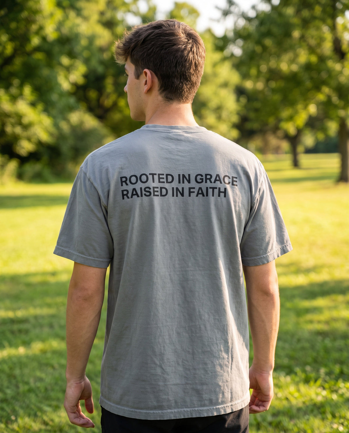 Back of a grey Rooted in Grace. Raised in Faith Christian t-shirt showing the large back print