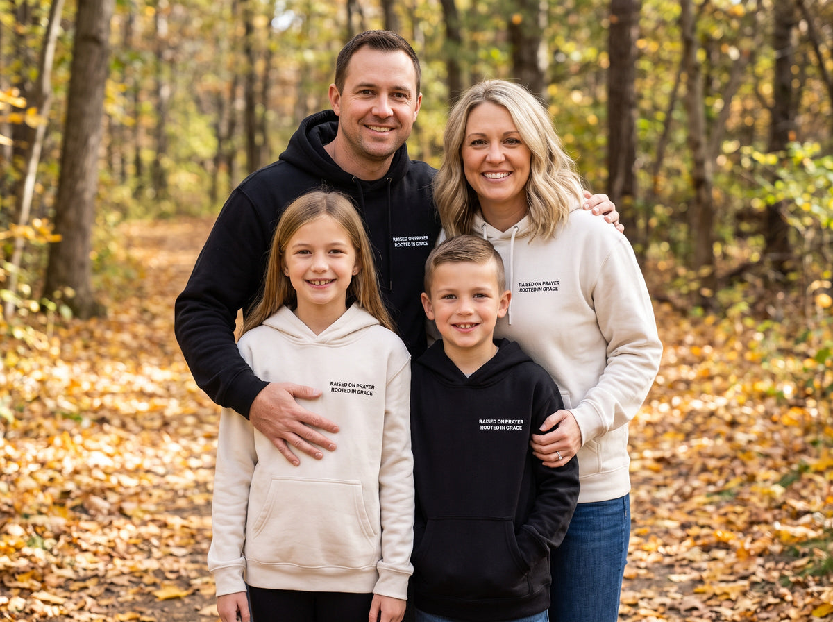 Family wearing matching Raised on Prayer. Rooted in Grace Christian hoodies