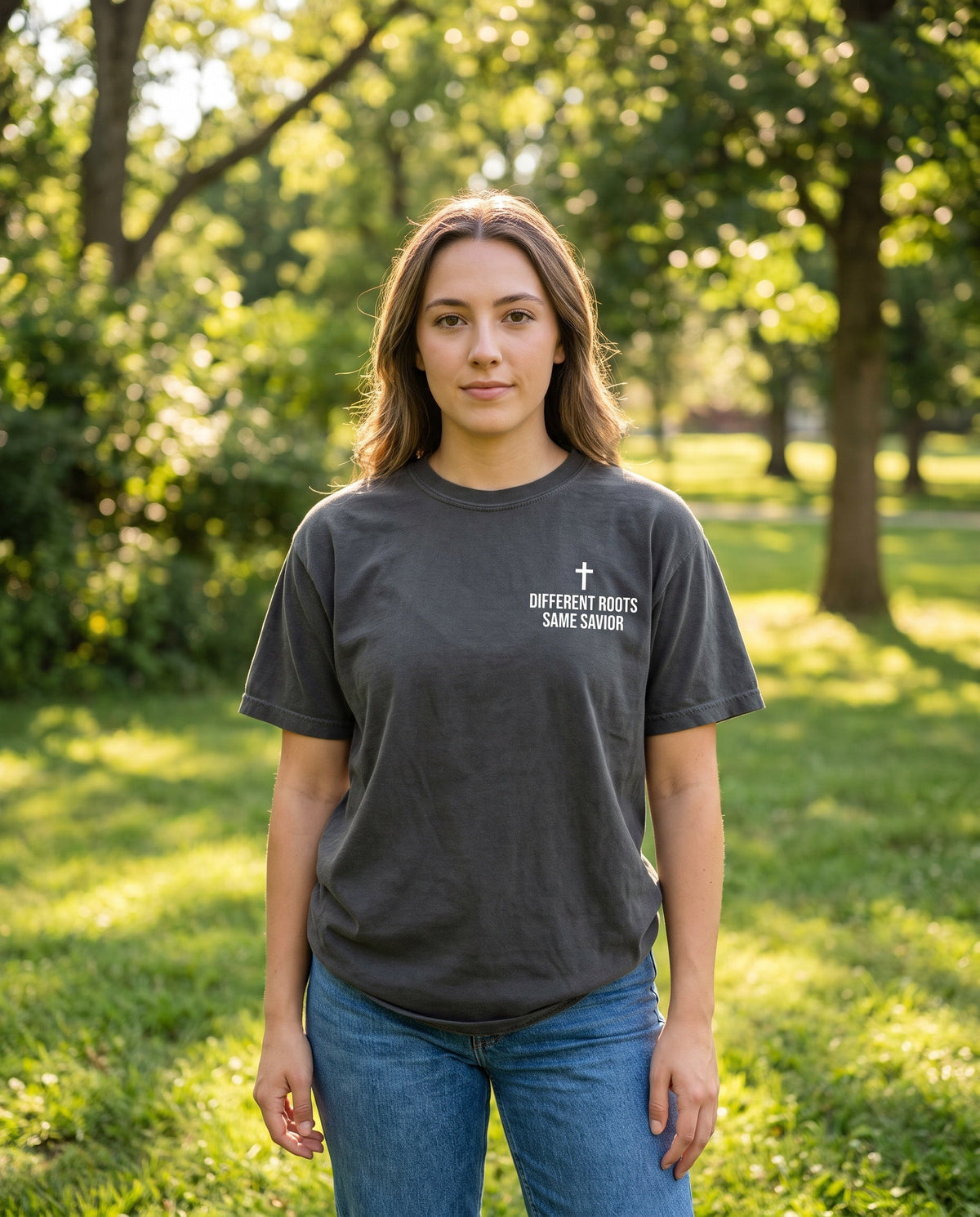 Woman wearing a pepper Different Roots. Same Savior Cross Edition Christian t-shirt with cross chest print
