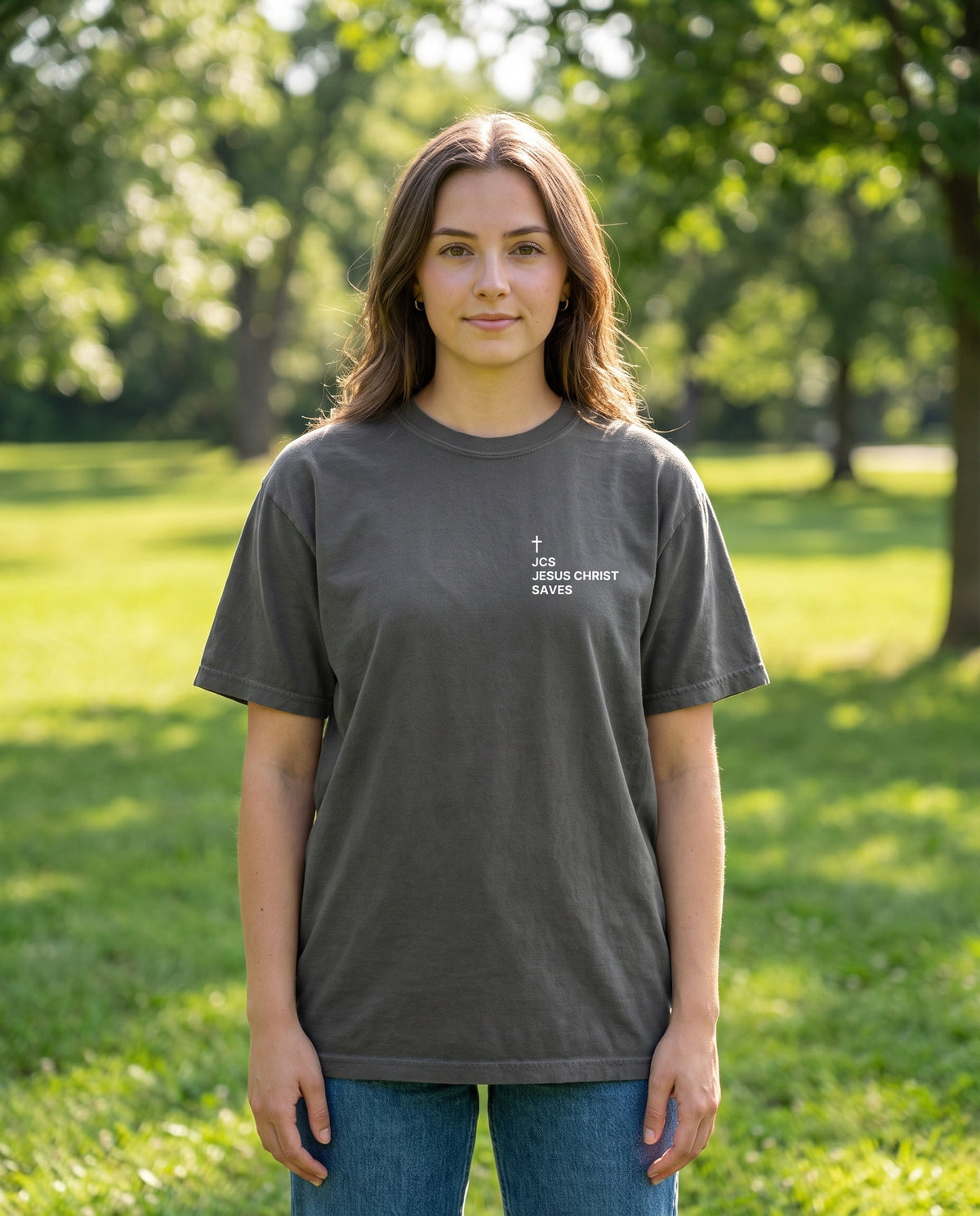 Woman wearing a pepper JCS — Jesus Christ Saves Cross Edition Christian t-shirt with cross chest print