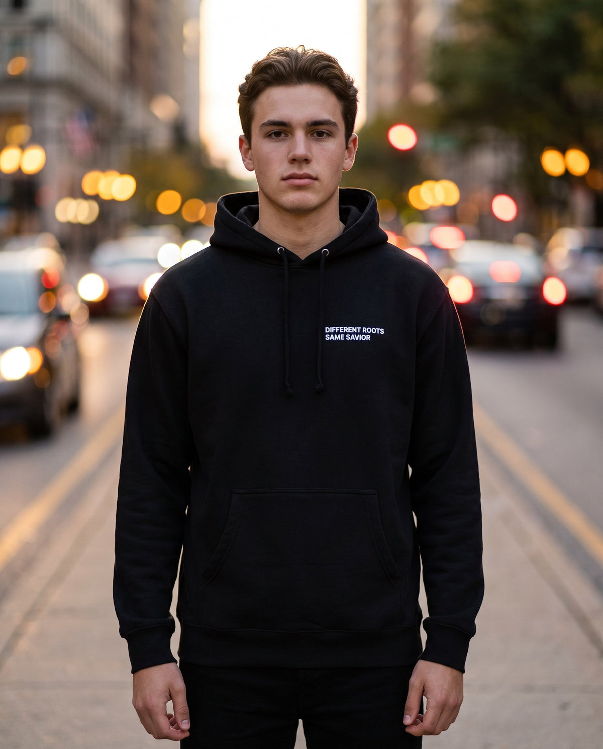 Man wearing a black Different Roots. Same Savior Christian hoodie, chest print