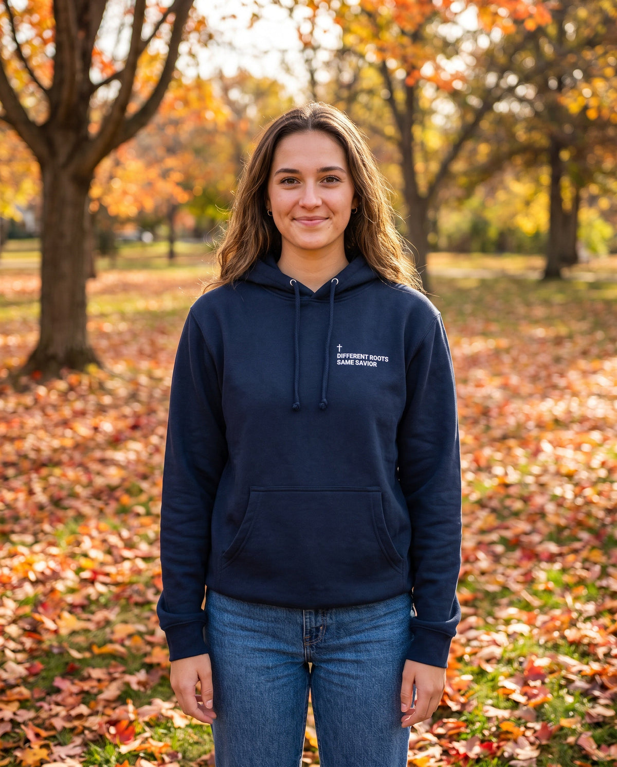 Woman wearing a navy Different Roots. Same Savior Cross Edition Christian hoodie with cross chest print