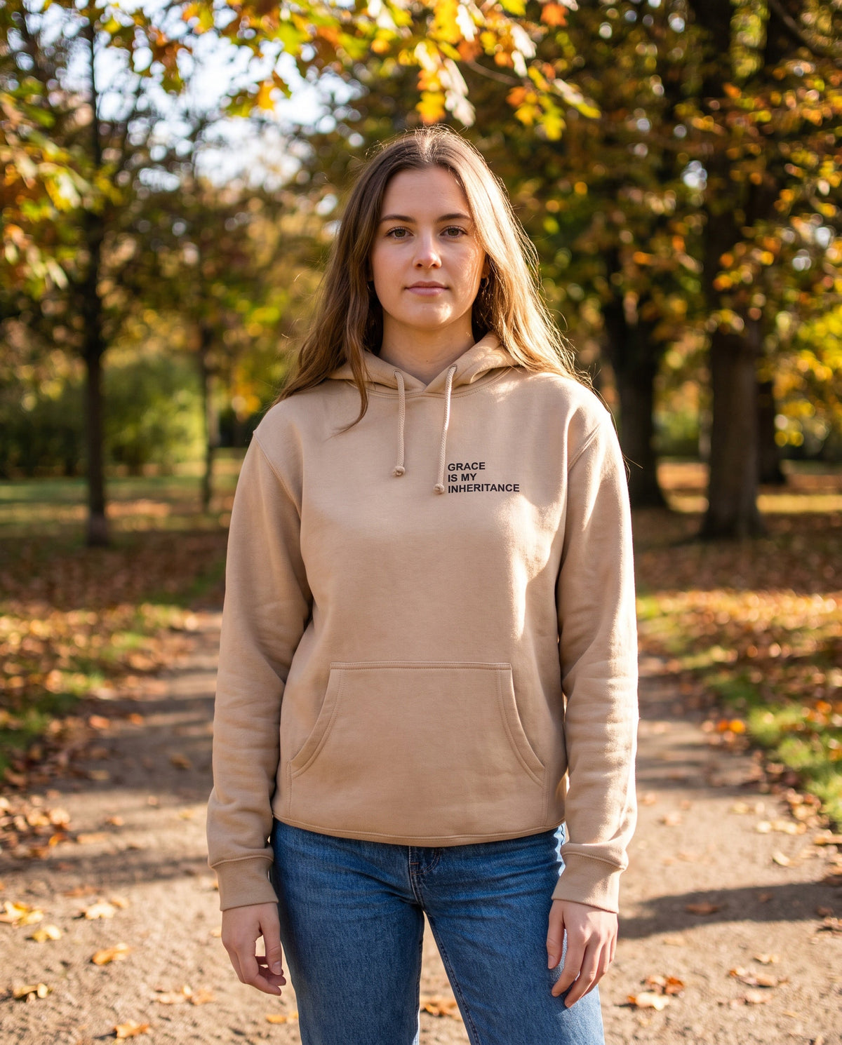 Woman wearing a sandstone Grace Is My Inheritance Christian hoodie, chest print