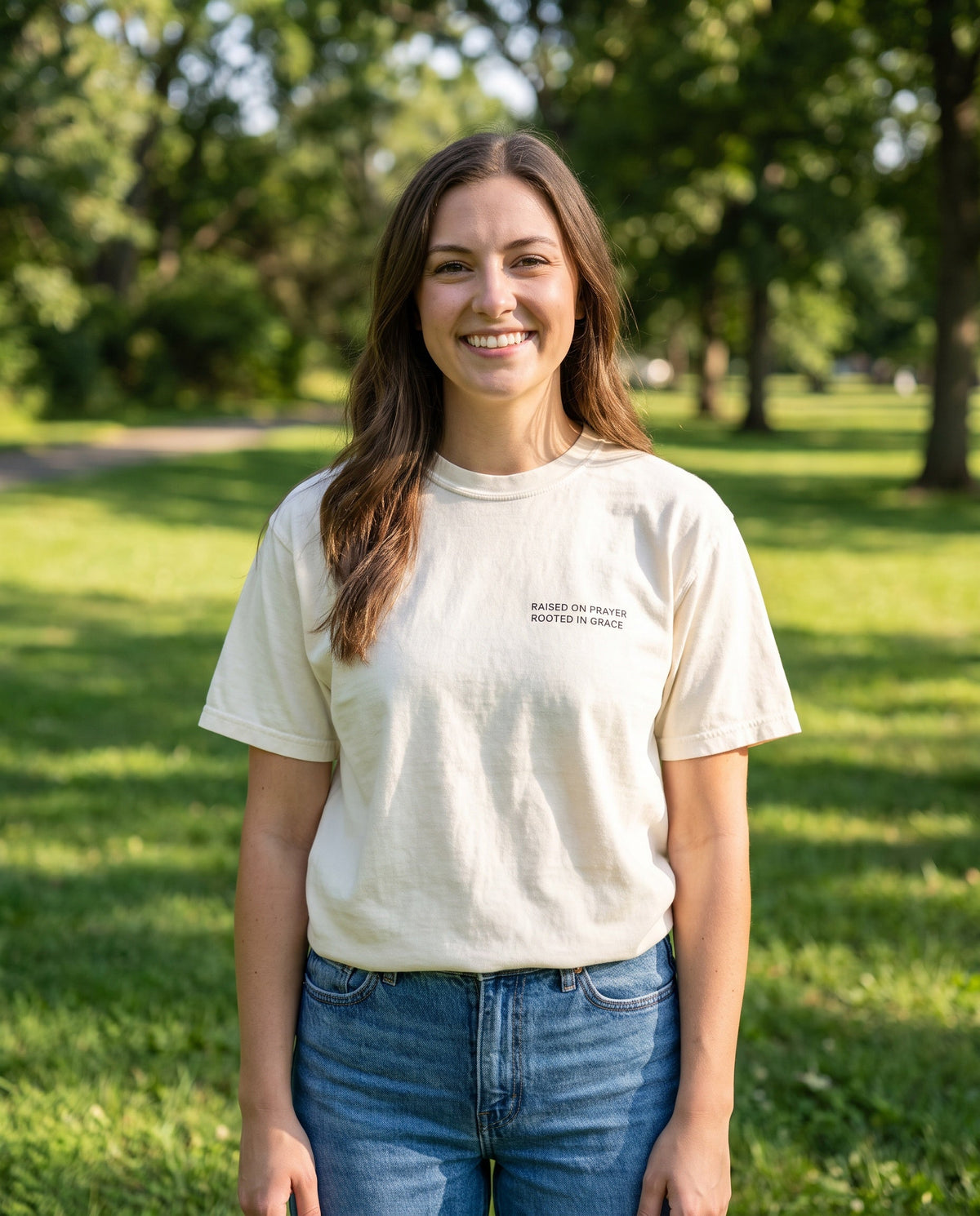 Woman wearing a ivory Raised on Prayer. Rooted in Grace Christian t-shirt, chest print