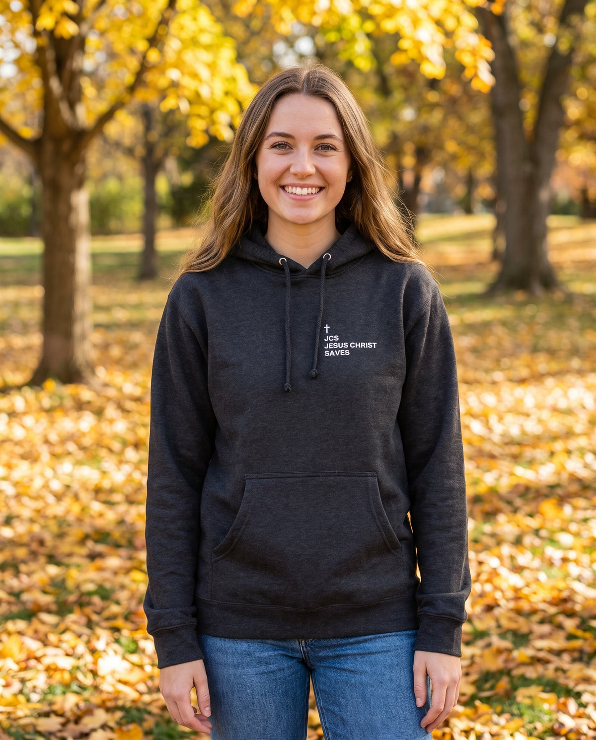 Woman wearing a charcoal heather JCS Jesus Christ Saves Cross Edition Christian hoodie with cross chest print