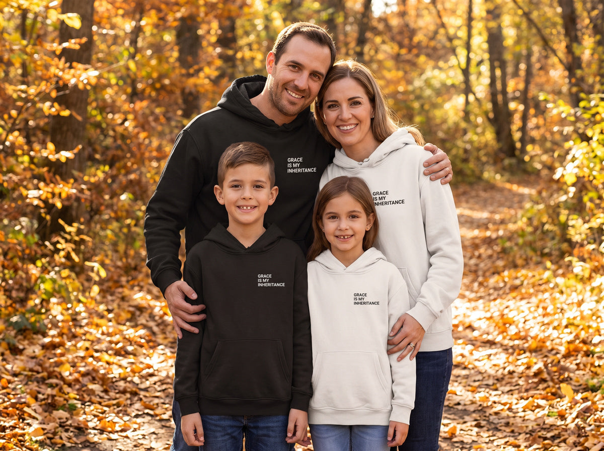 Family wearing matching Grace Is My Inheritance Christian hoodies in black and bone, autumn trail