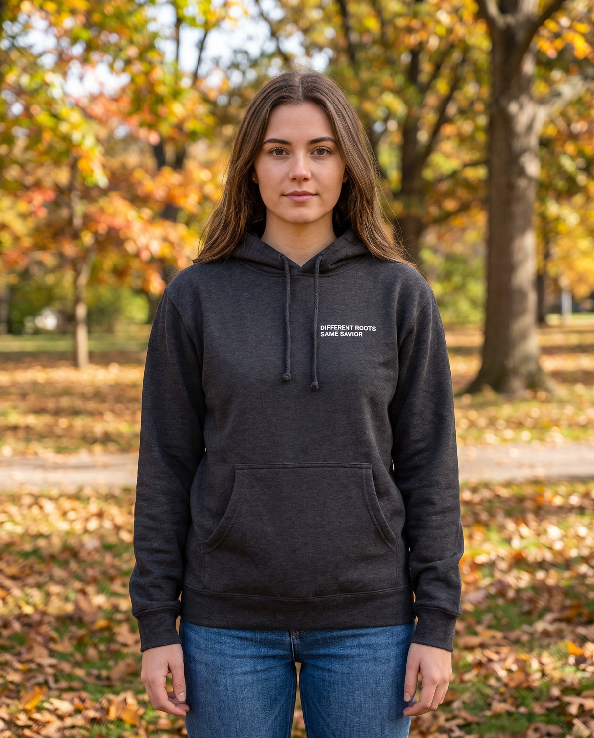 Woman wearing a charcoal Different Roots. Same Savior Christian hoodie, chest print
