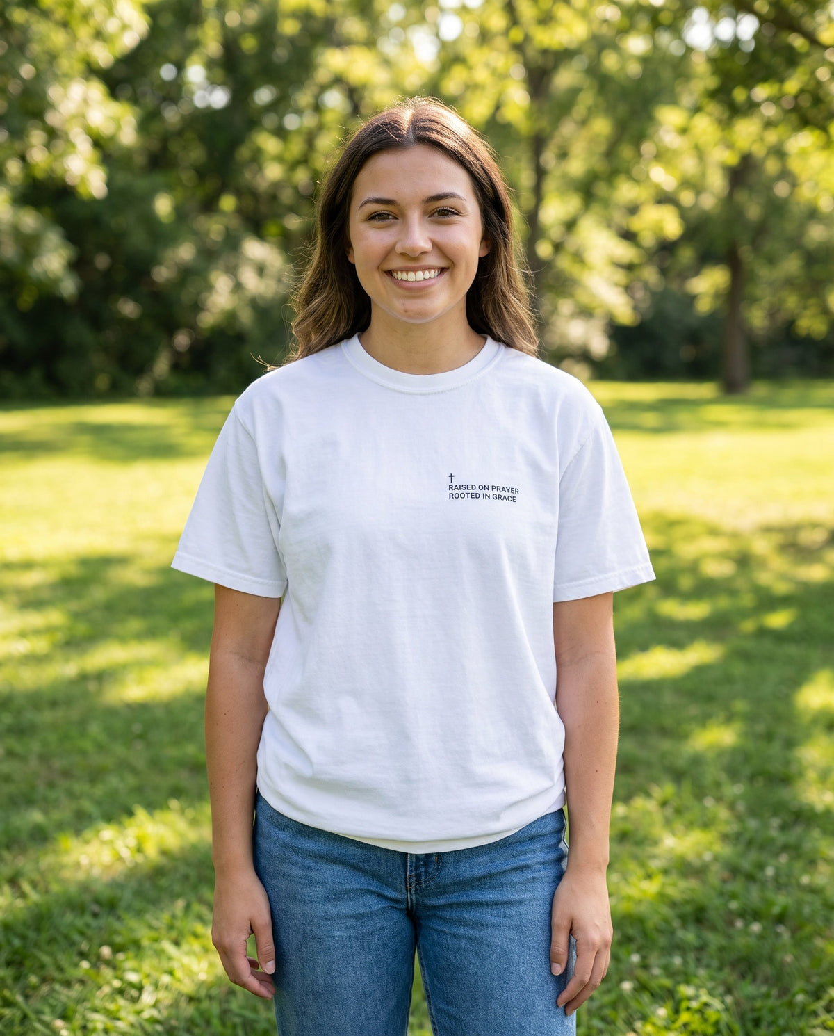Woman wearing a white Raised on Prayer. Rooted in Grace Cross Edition Christian t-shirt with cross chest print