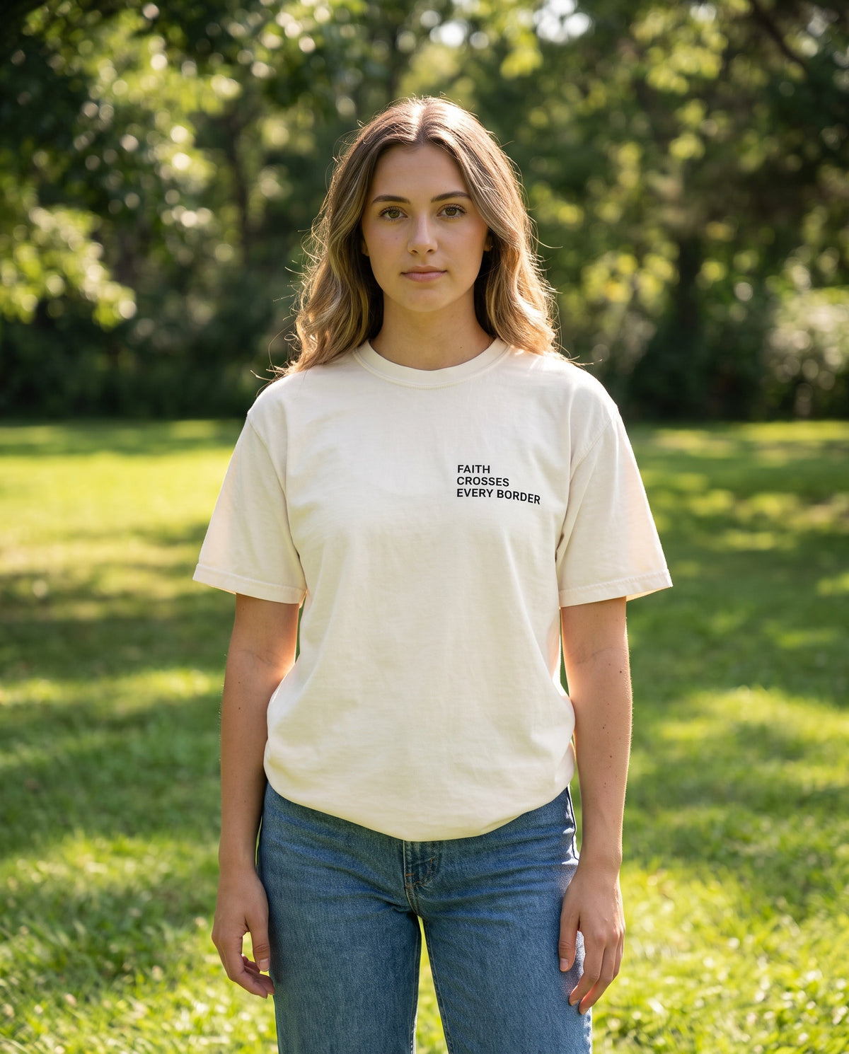 Woman wearing a ivory Faith Crosses Every Border Christian t-shirt, chest print