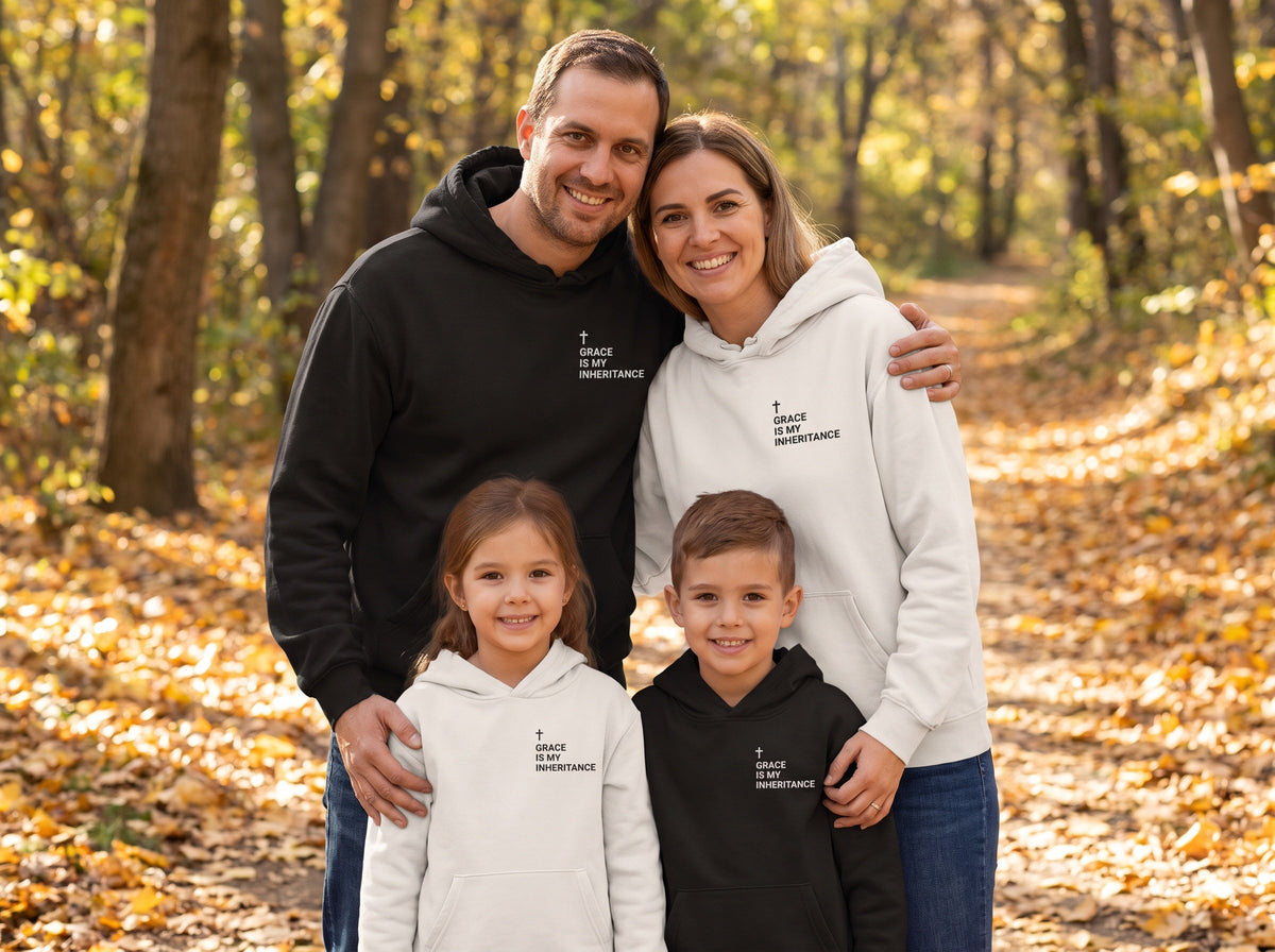 Family wearing matching Grace Is My Inheritance Cross Edition Christian hoodies in black and bone, autumn trail