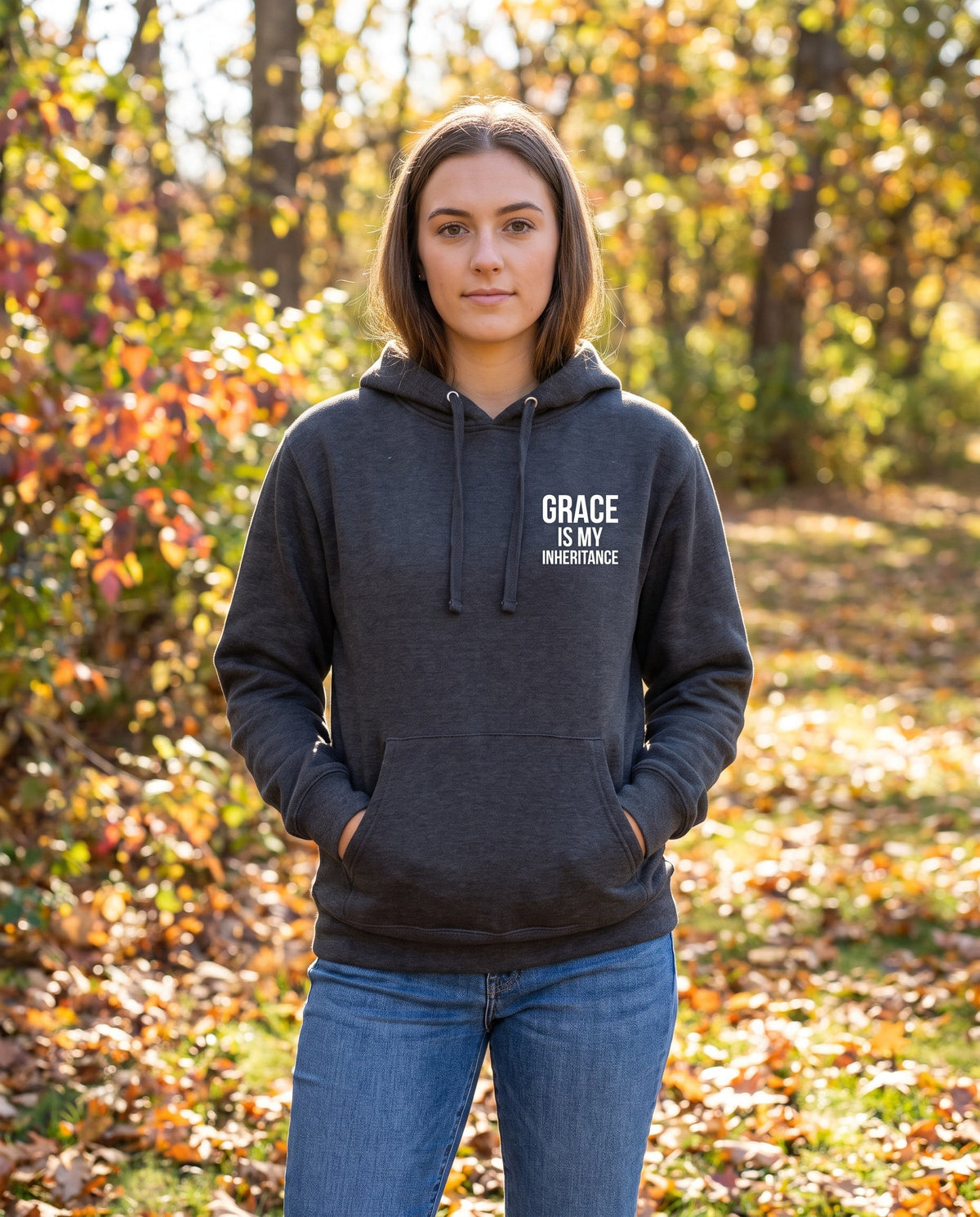 Woman wearing a charcoal heather Grace Is My Inheritance Christian hoodie, chest print