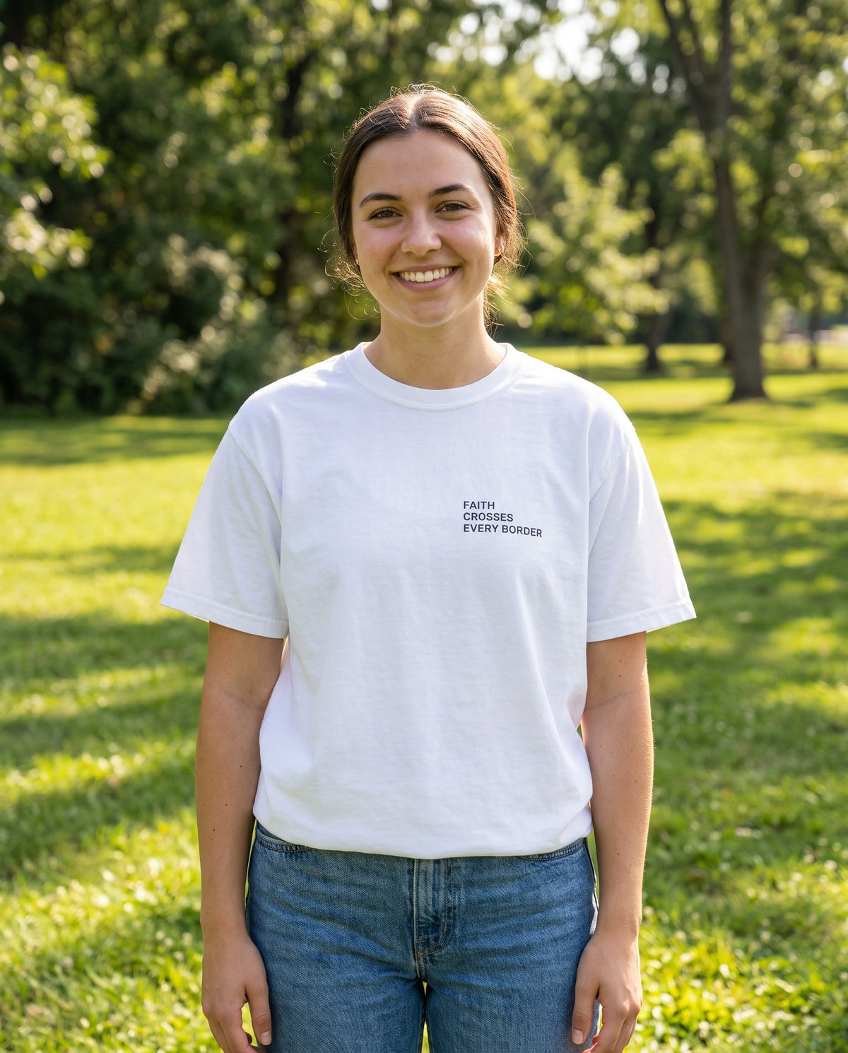 Woman wearing a white Faith Crosses Every Border Christian t-shirt, chest print