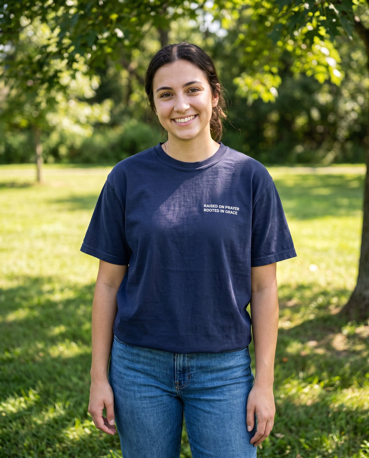 Woman wearing a truenavy Raised on Prayer. Rooted in Grace Christian t-shirt, chest print