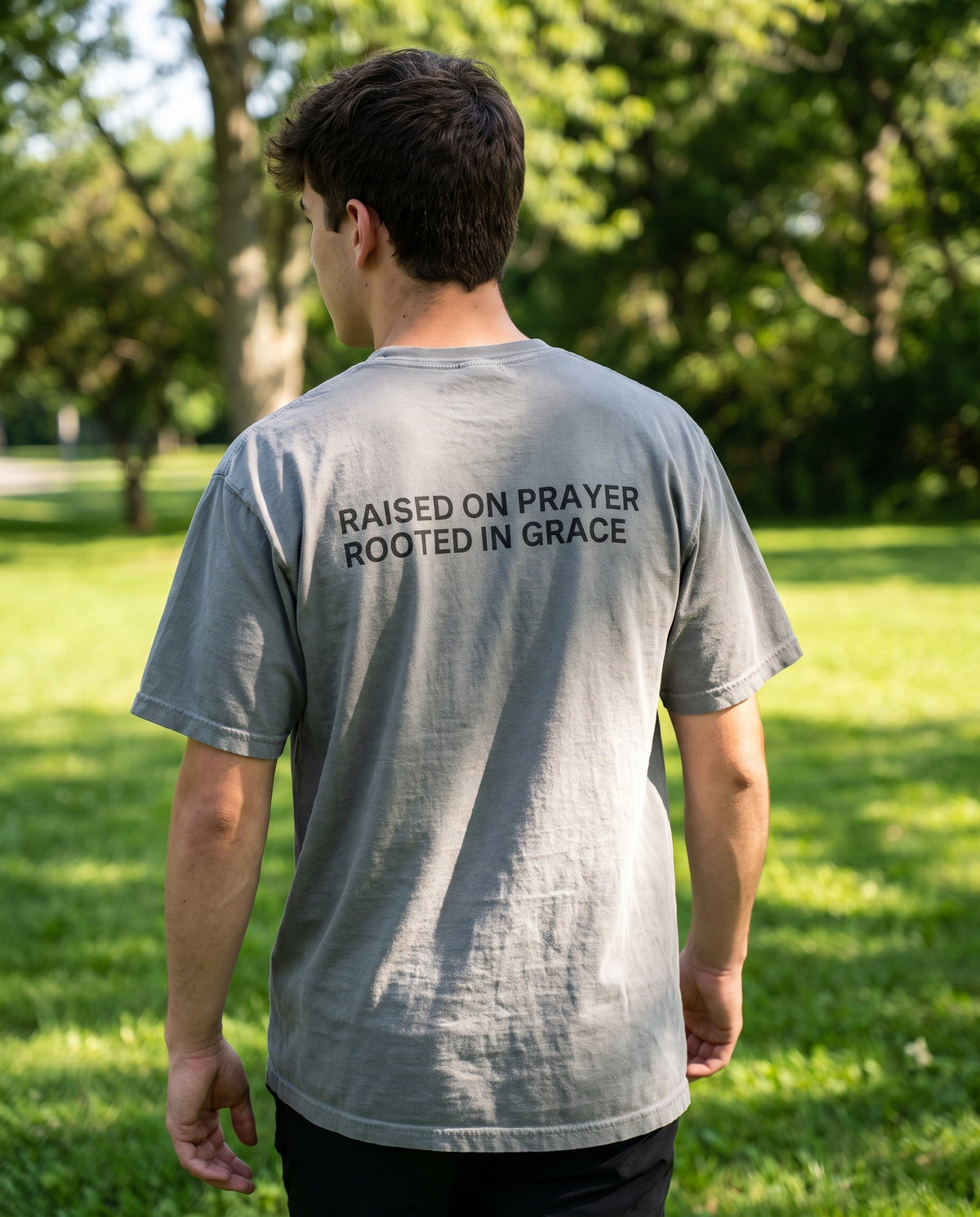 Back of a grey Raised on Prayer. Rooted in Grace Christian t-shirt showing the large back print